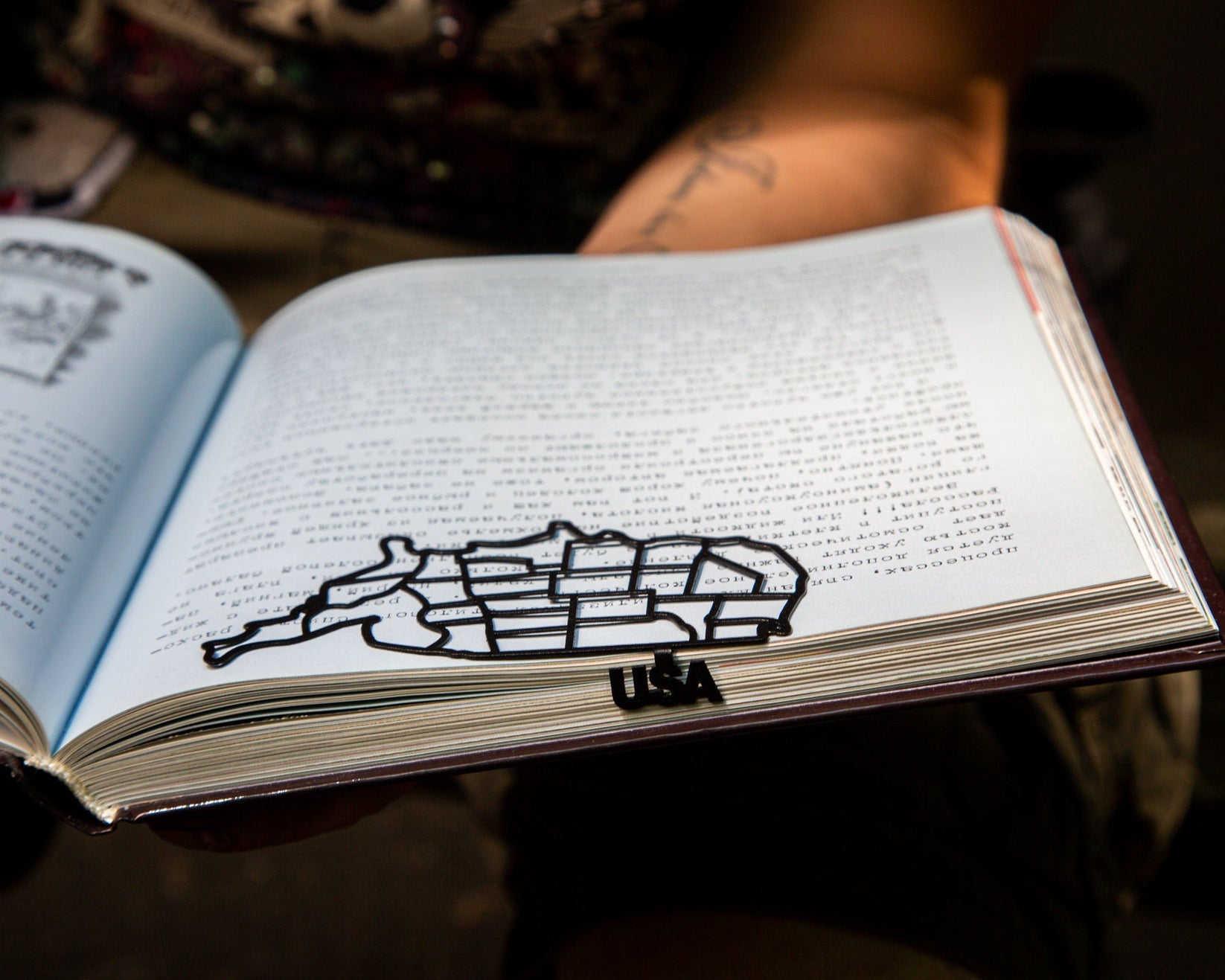 Map of USA metal bookmark lying across the pages of an open book