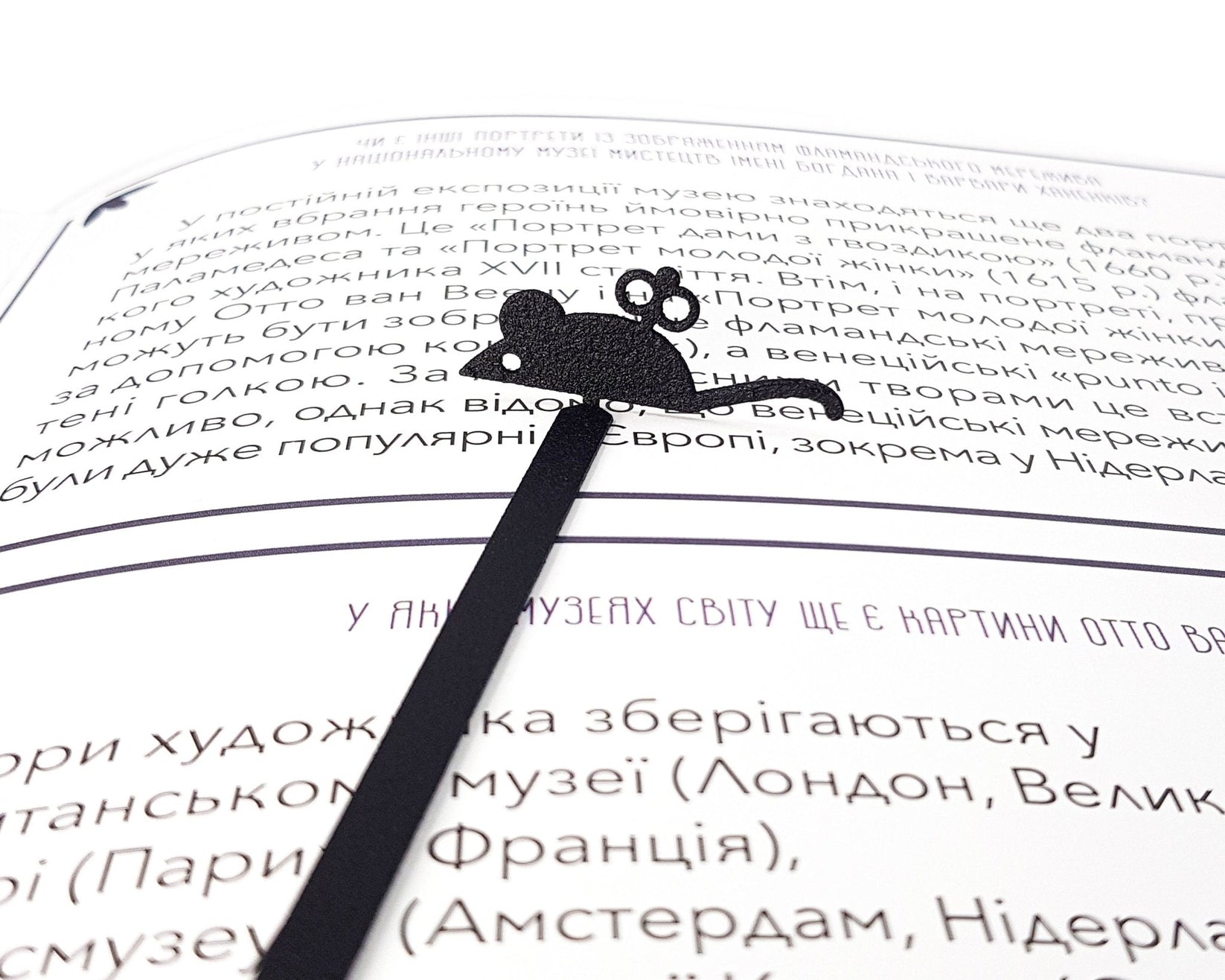 Mechanical Mouse metal bookmark marking a page in an open book