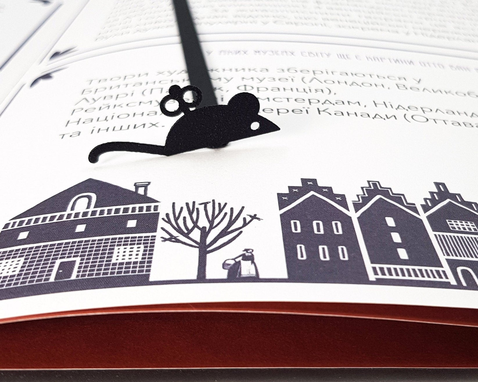 Mechanical Mouse metal bookmark marking a page in an illustrated book