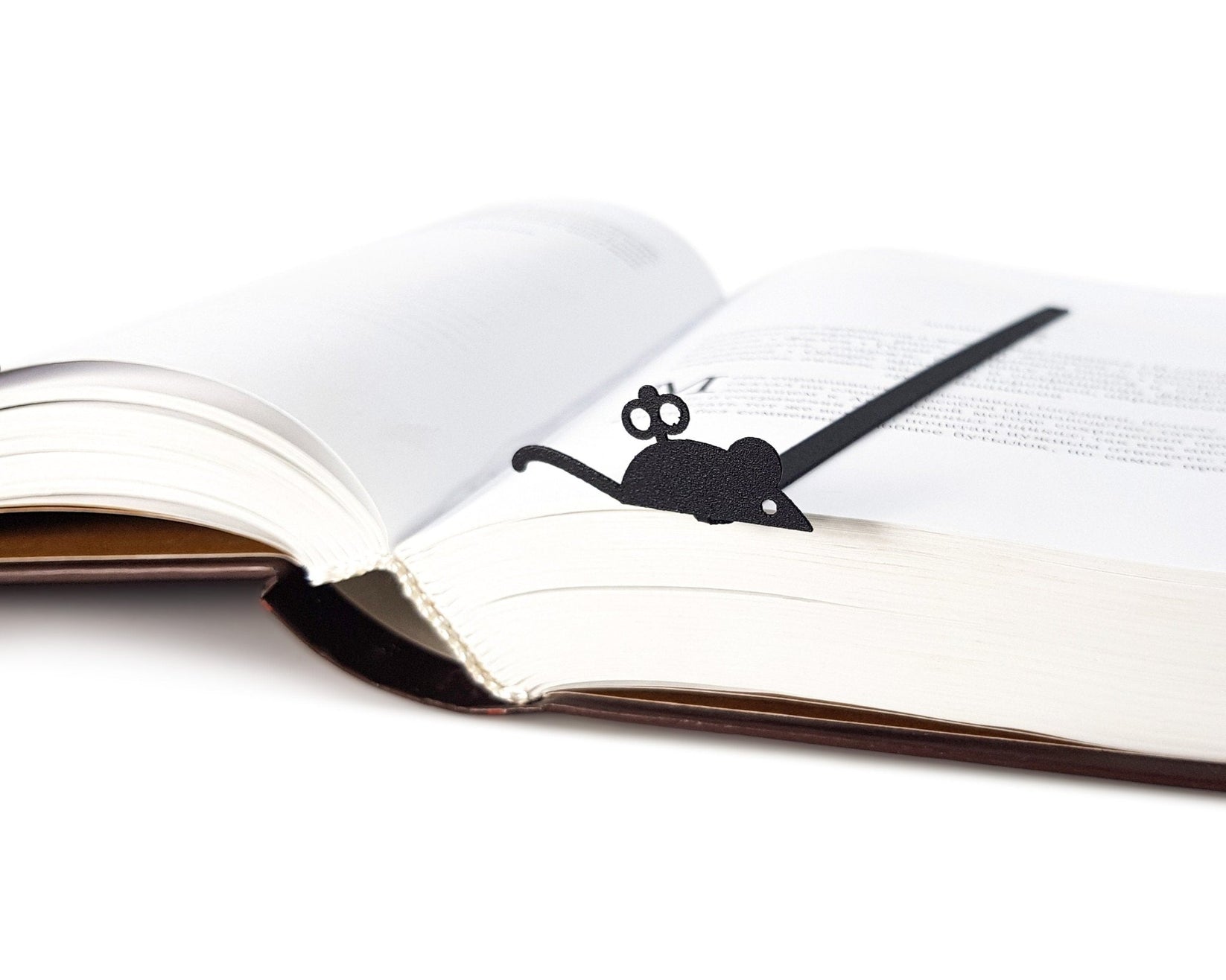 Mechanical Mouse metal bookmark lying across the pages of an open book