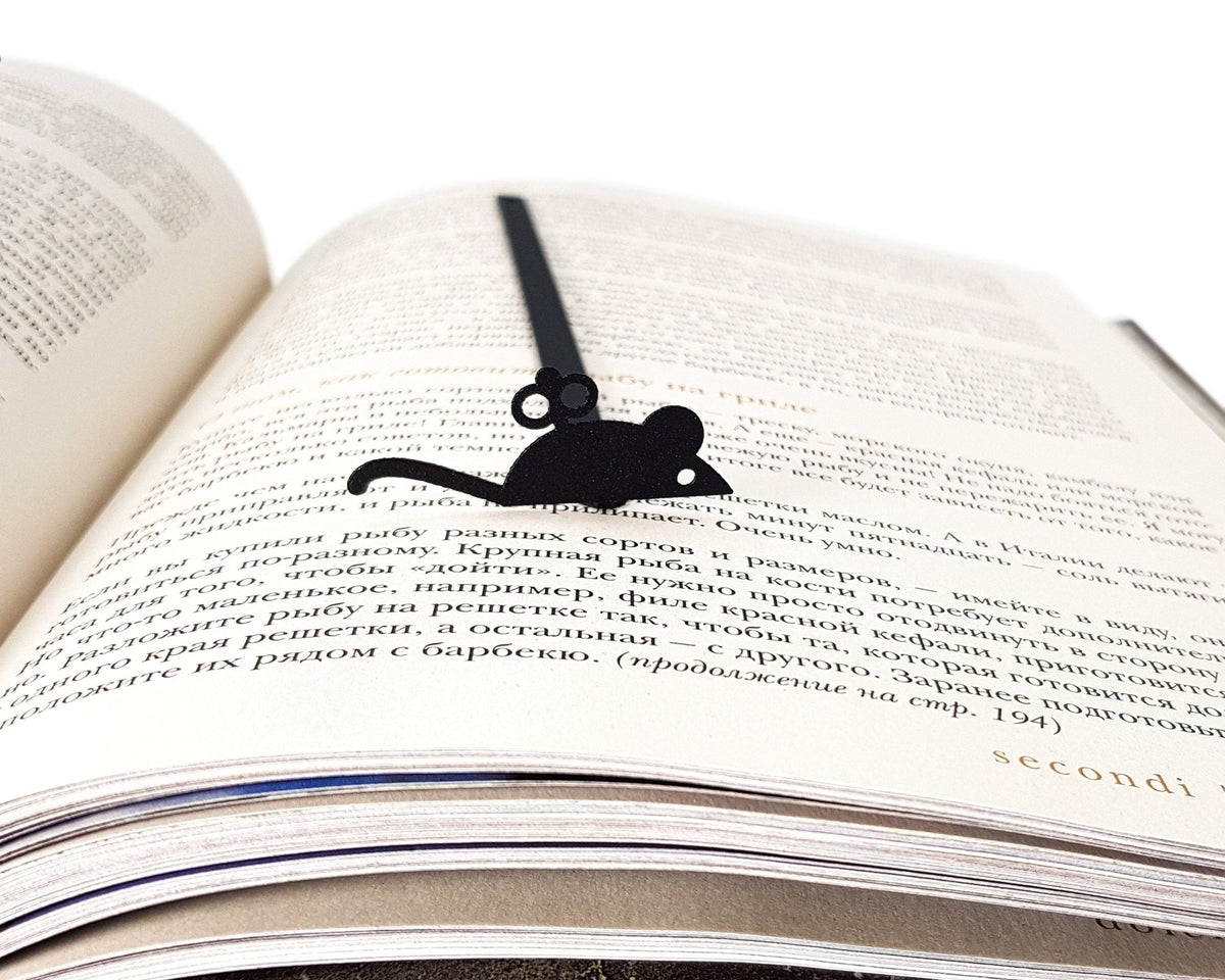 Mechanical Mouse metal bookmark set into the gutter of an open book