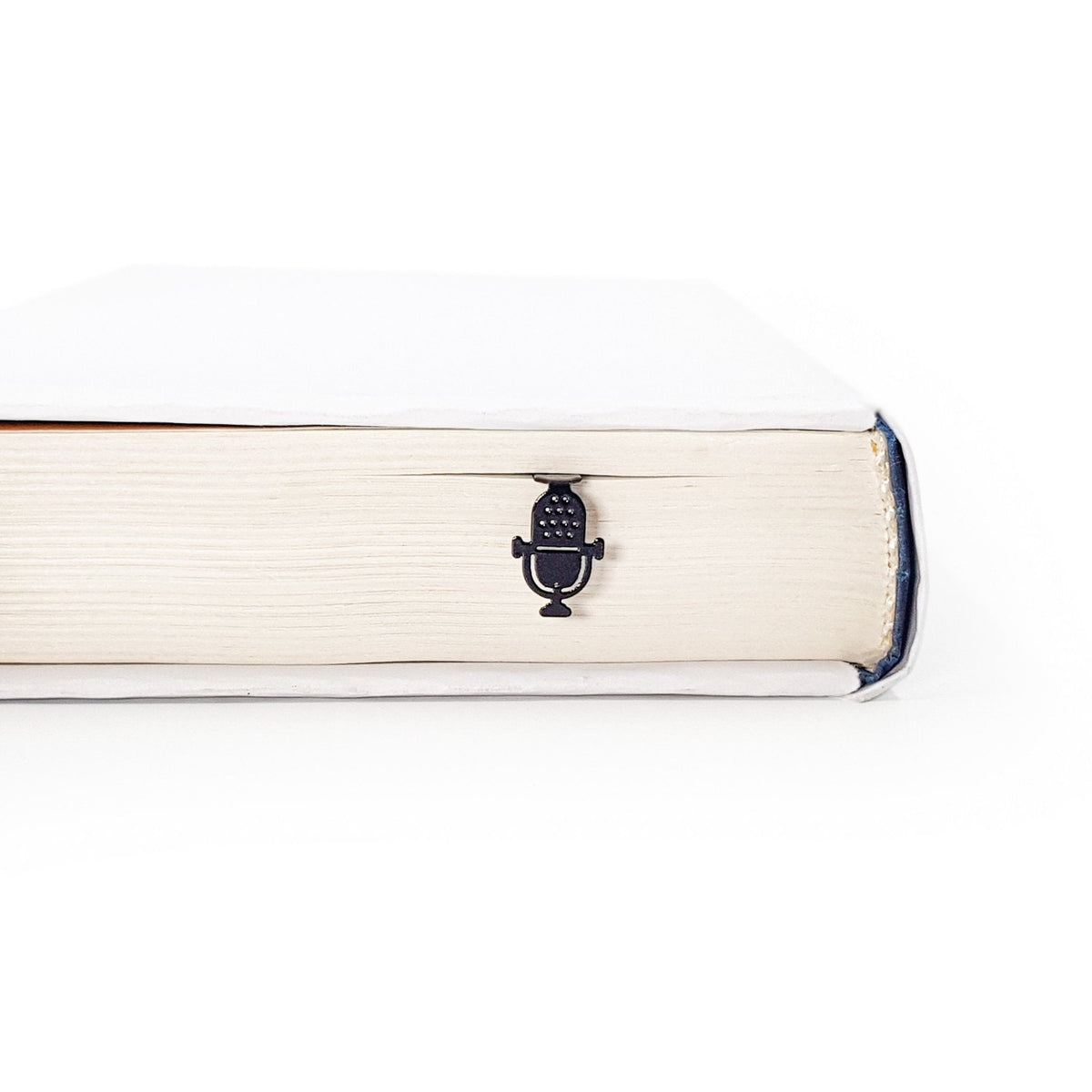 Microphone metal bookmark in a closed book, only its top showing above the pages