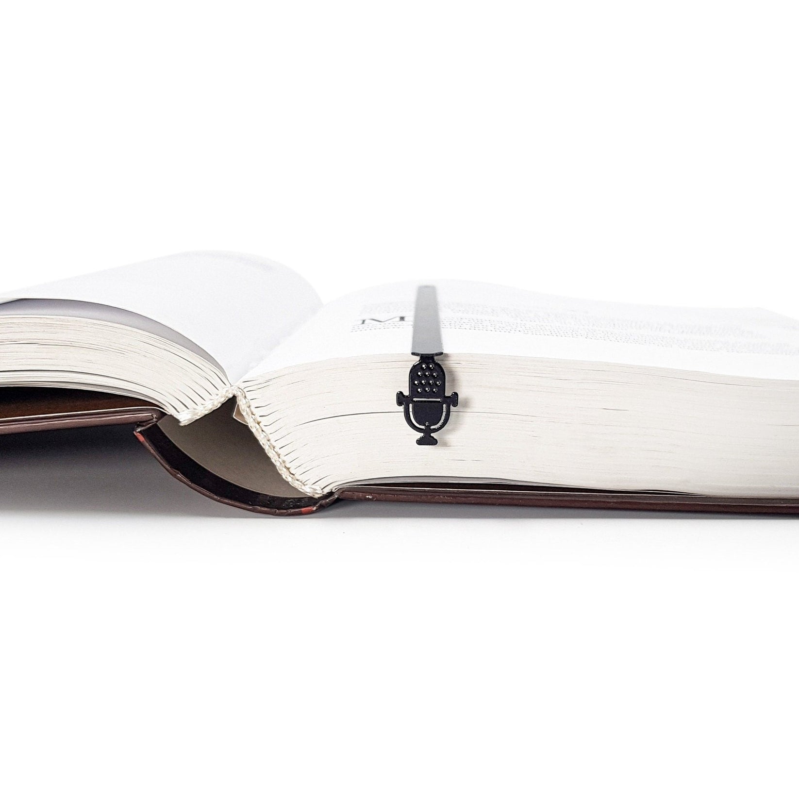 Microphone metal bookmark resting on the pages of an open book