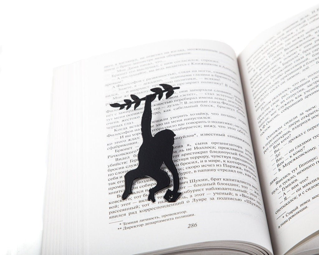 Monkey, Library in the Jungle metal bookmark resting on the pages of an open book