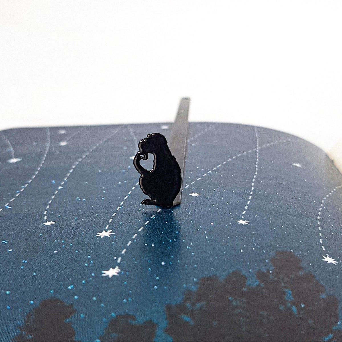 Monkey the Thinker metal bookmark on a coloured background