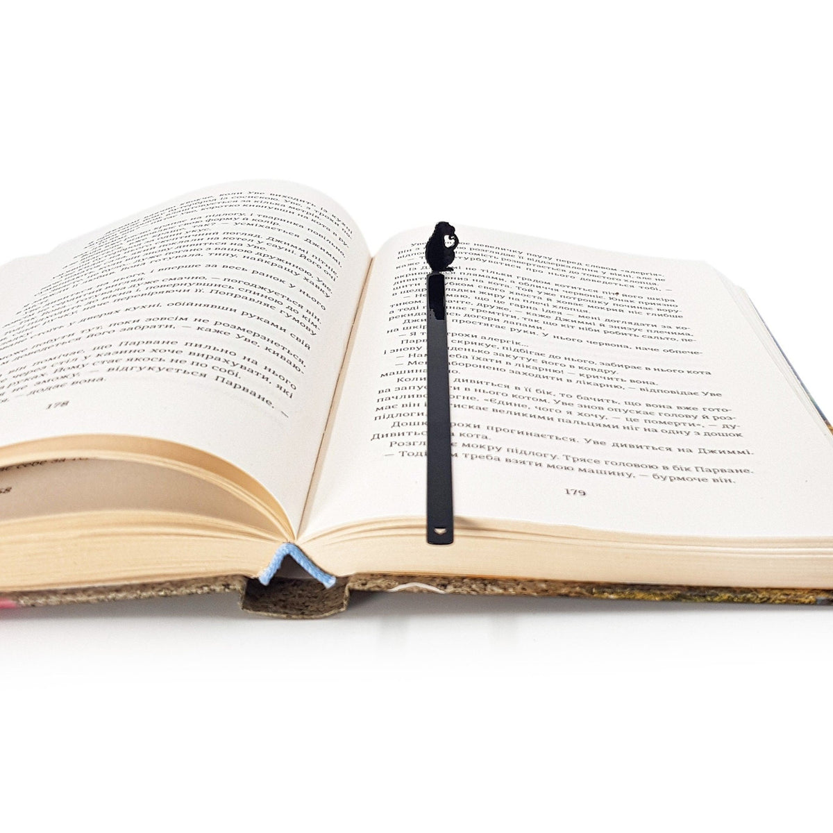 Monkey the Thinker metal bookmark marking a page in an open book