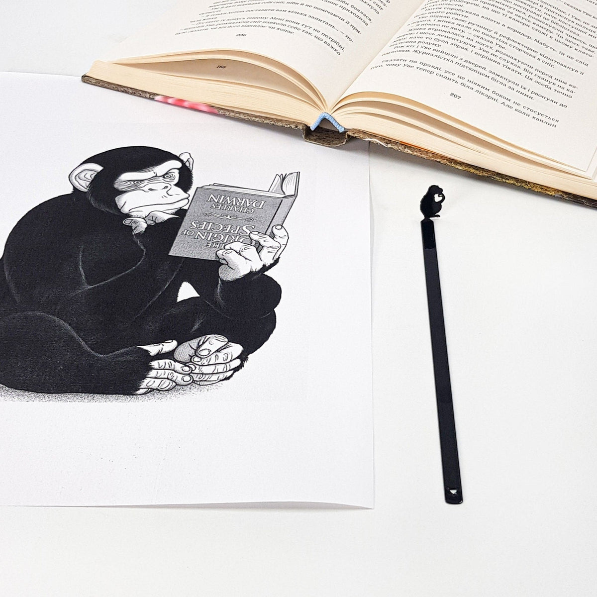 Monkey the Thinker metal bookmark on an illustrated page