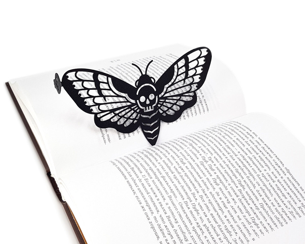 Moth of Death metal bookmark marking a page in an open book, view 6