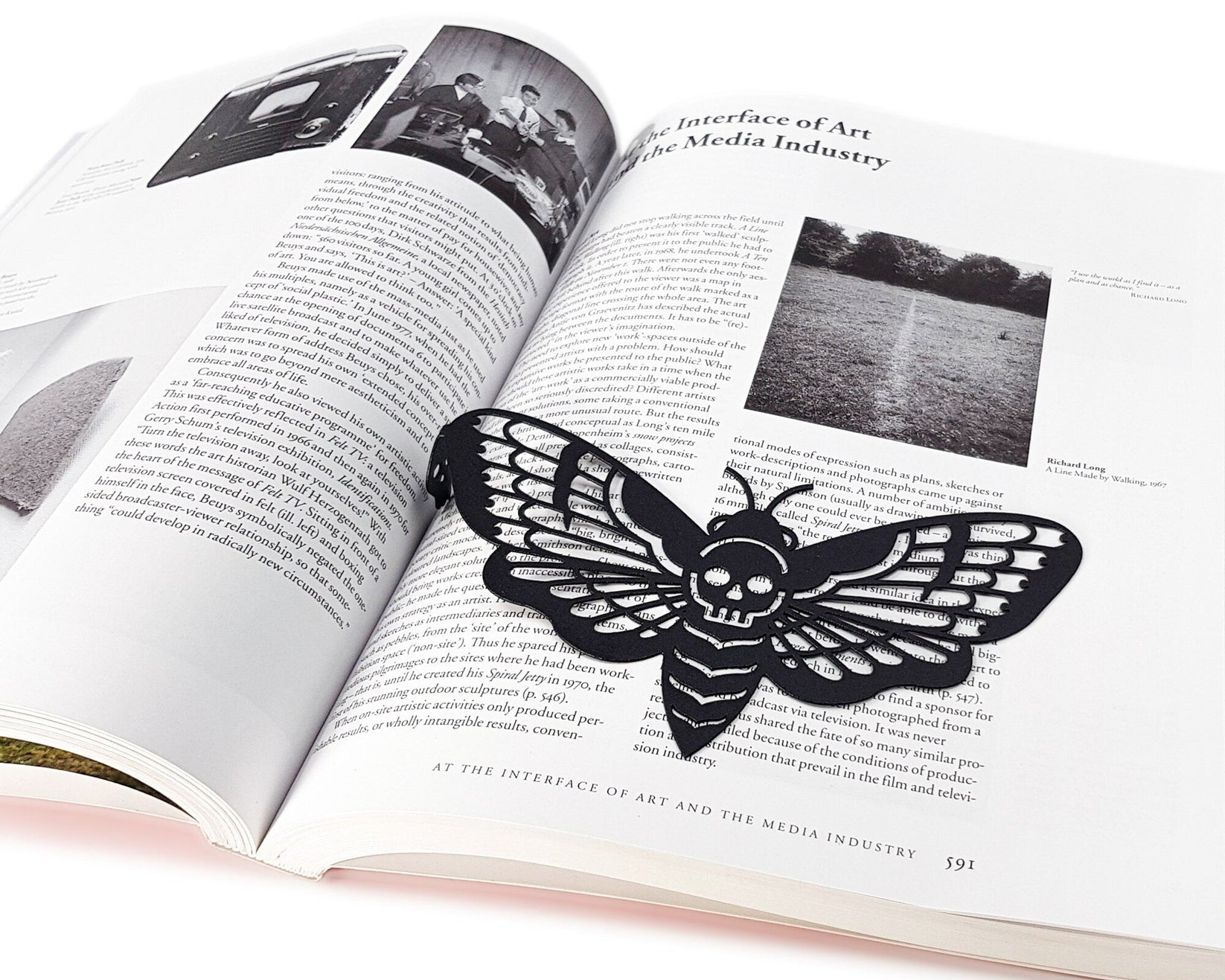 Moth of Death metal bookmark marking a page in an illustrated book