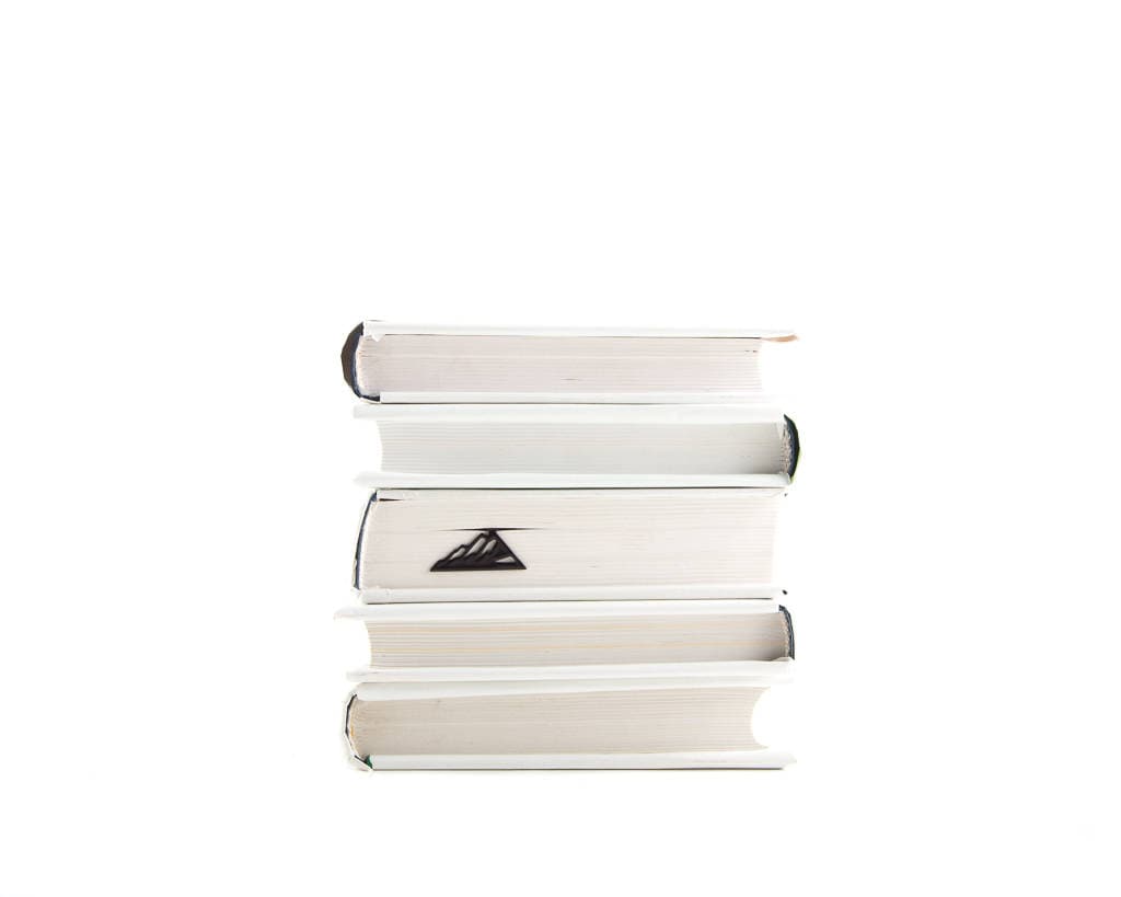 Mountain Climber metal bookmark shown with a stack of books