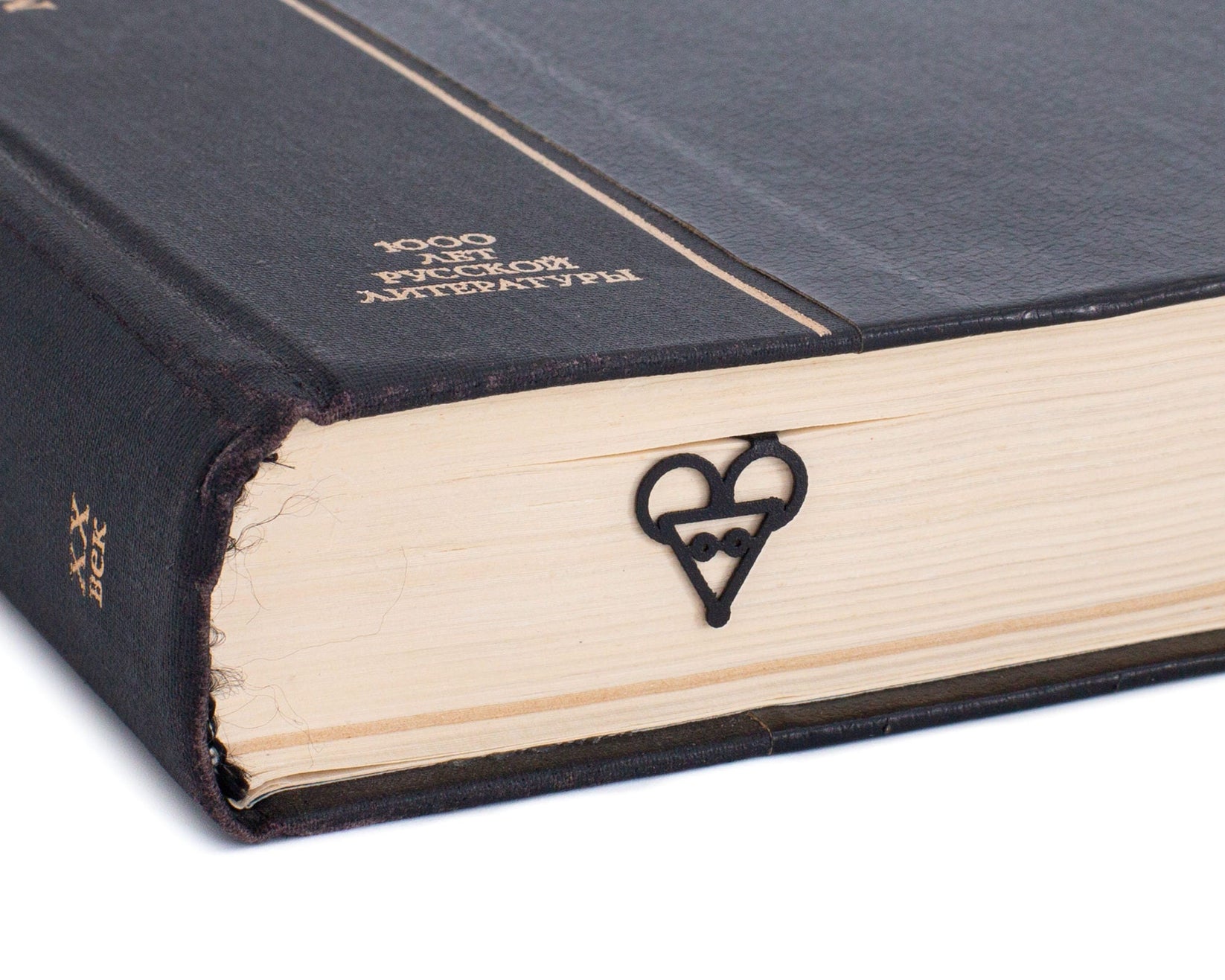 Mouse Head metal bookmark in a closed book, only its top showing above the pages