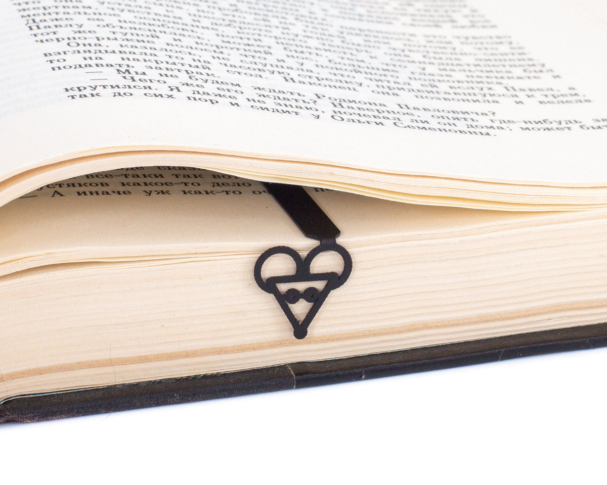 Mouse Head metal bookmark marking a page in an open book