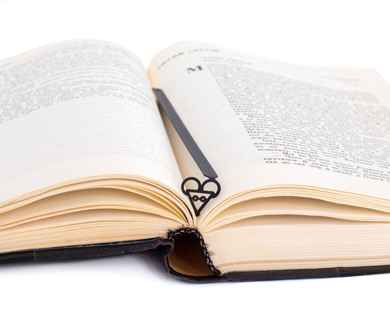 Mouse Head metal bookmark resting on the pages of an open book