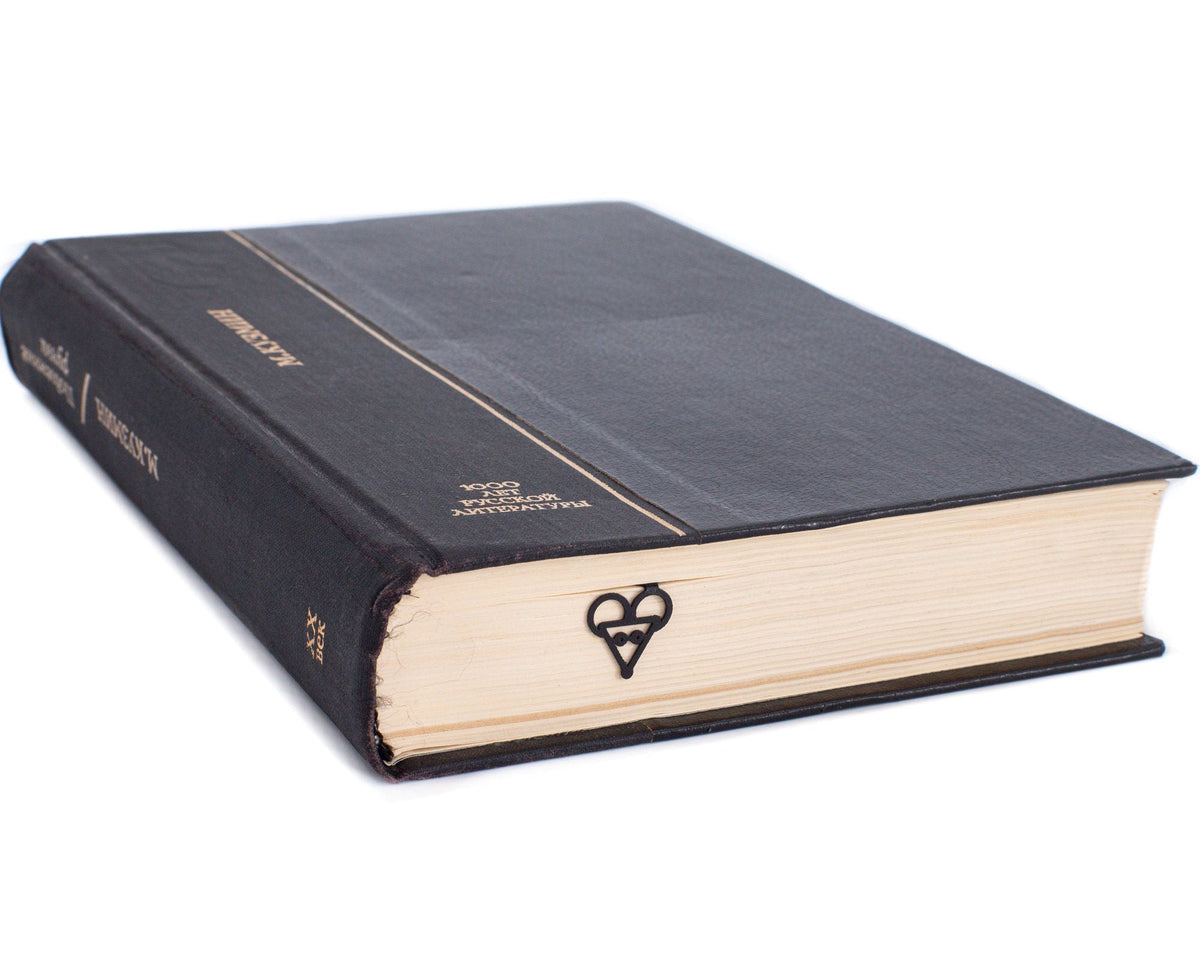 Mouse Head metal bookmark seen from the edge of a closed book