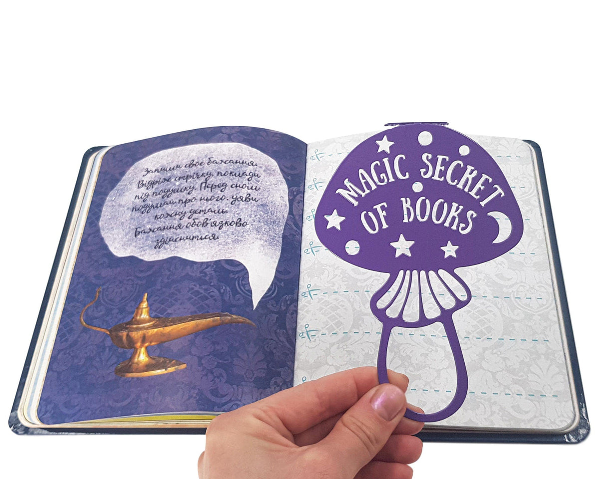 Mushroom metal bookmark in blue marking a page in an illustrated book