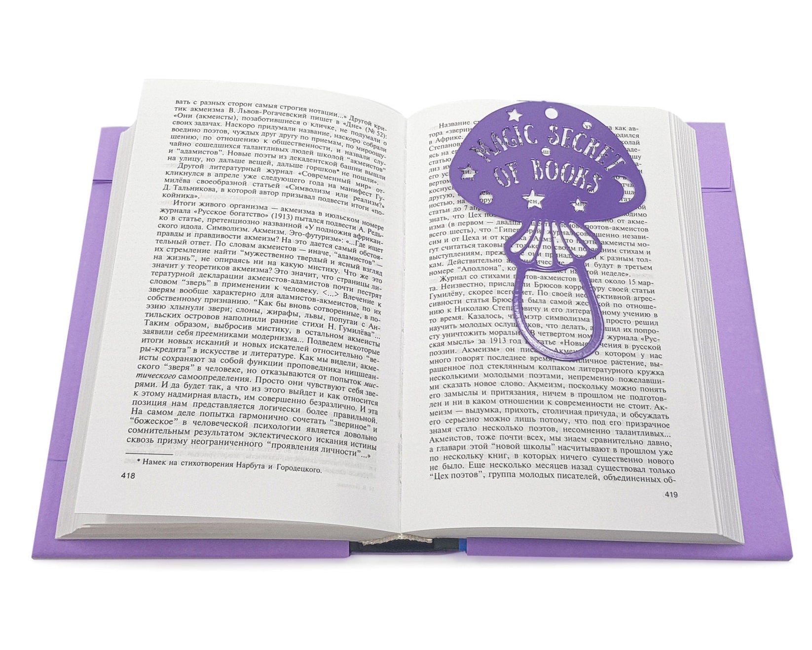 Mushroom metal bookmark in blue lying across the pages of an open book