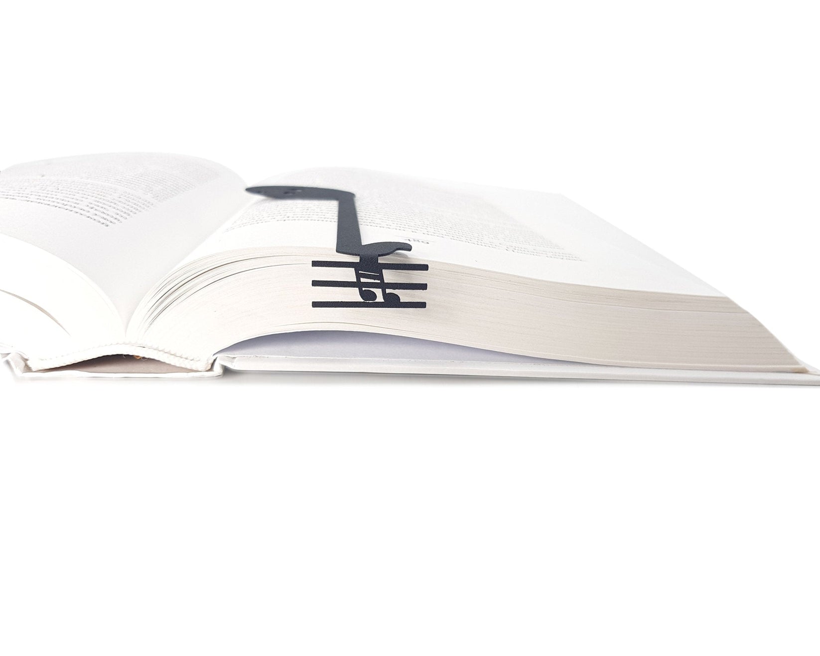Musical Note metal bookmark lying across the pages of an open book