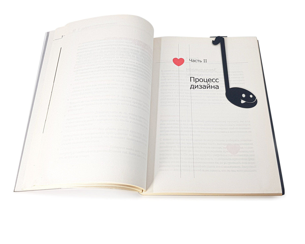 Musical Note metal bookmark resting on the pages of an open book