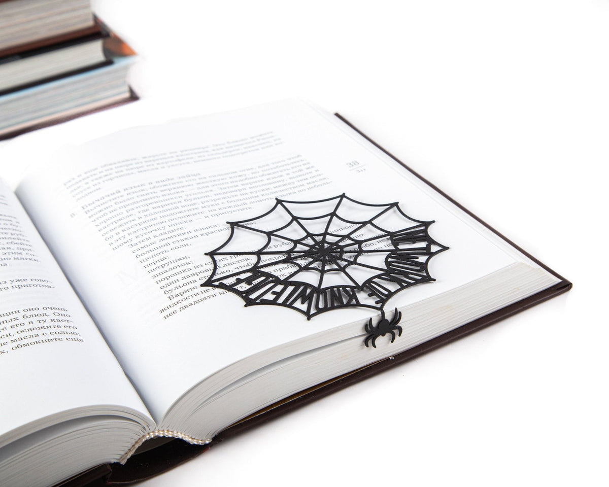 Network of Knowledge metal bookmark resting on the pages of an open book