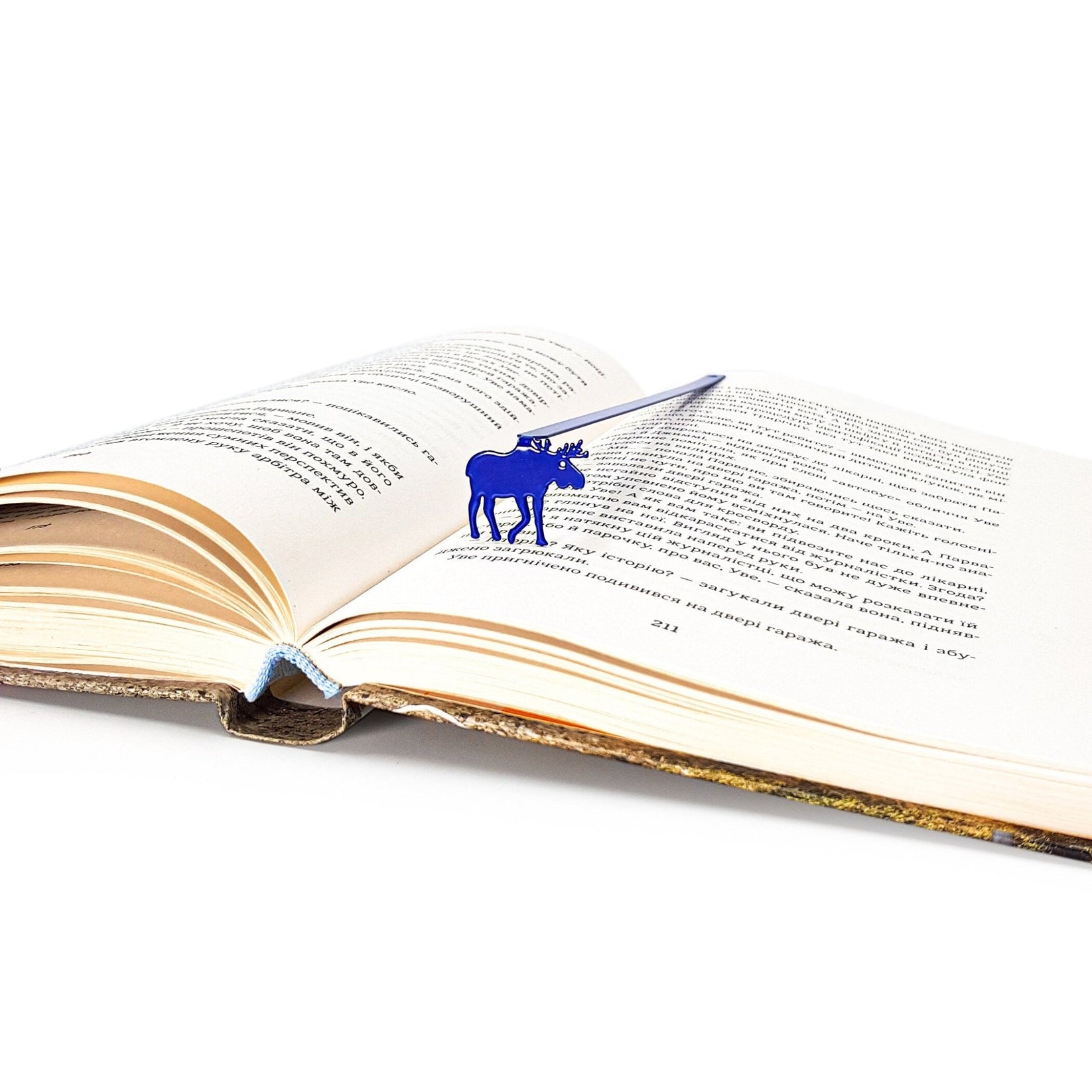 Norwegian Moose metal bookmark in blue marking a page in an open book
