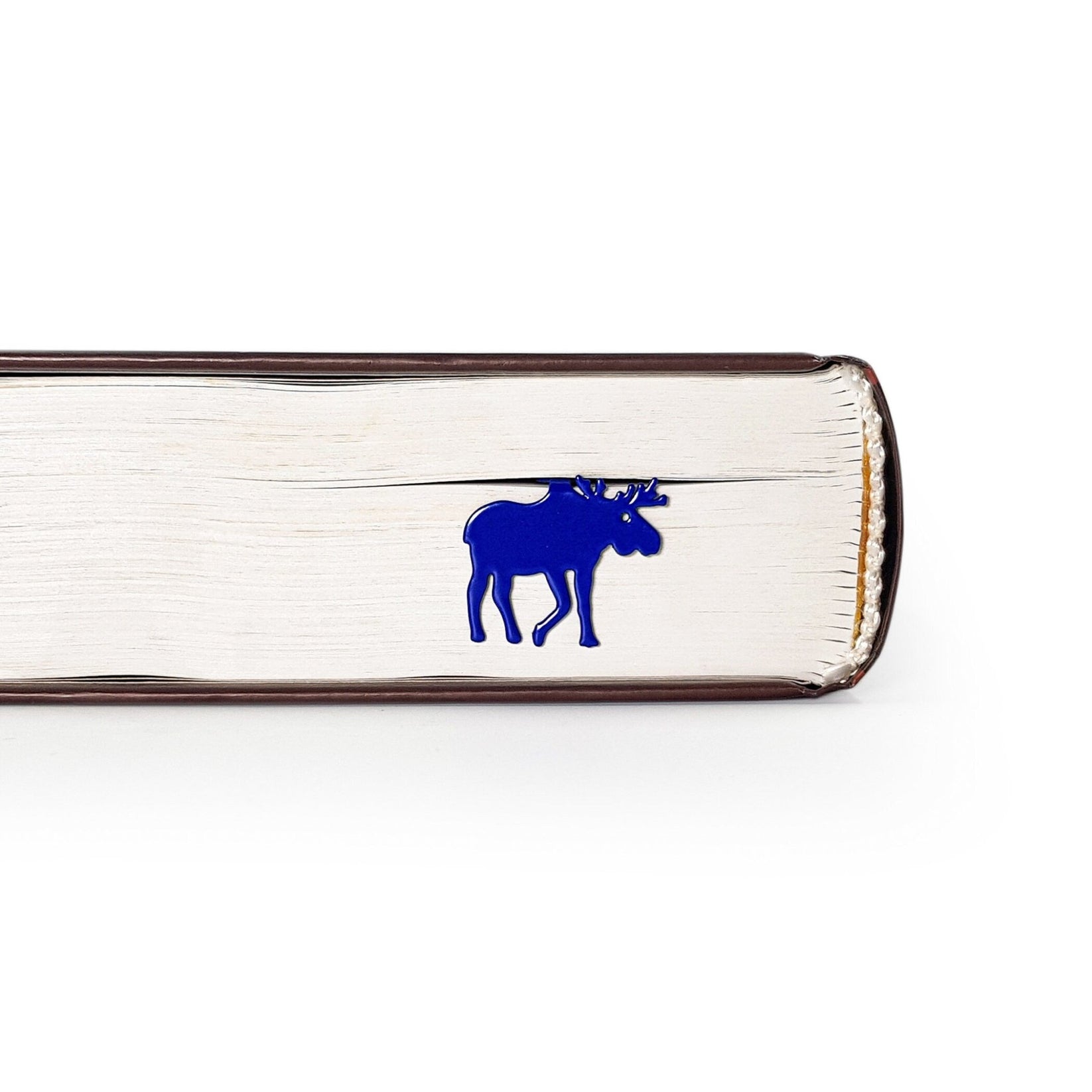 Norwegian Moose metal bookmark in blue in a closed book, only its top showing above the pages
