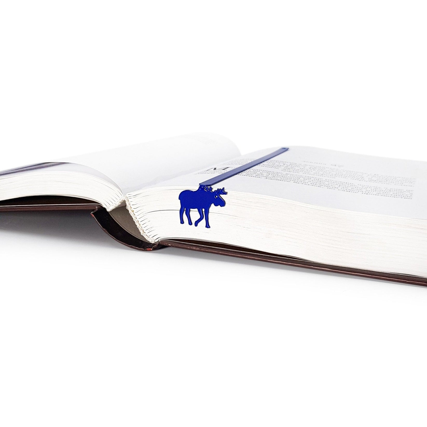 Norwegian Moose metal bookmark in blue resting on the pages of an open book, view 5