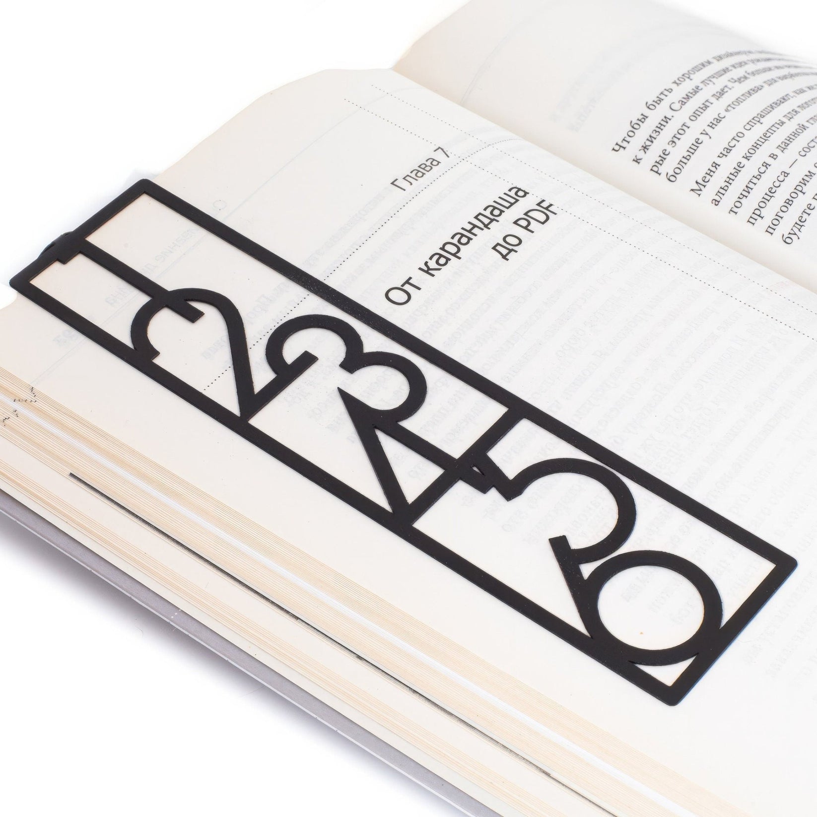 Numbers Bauhaus Style metal bookmark marking a page in an open book