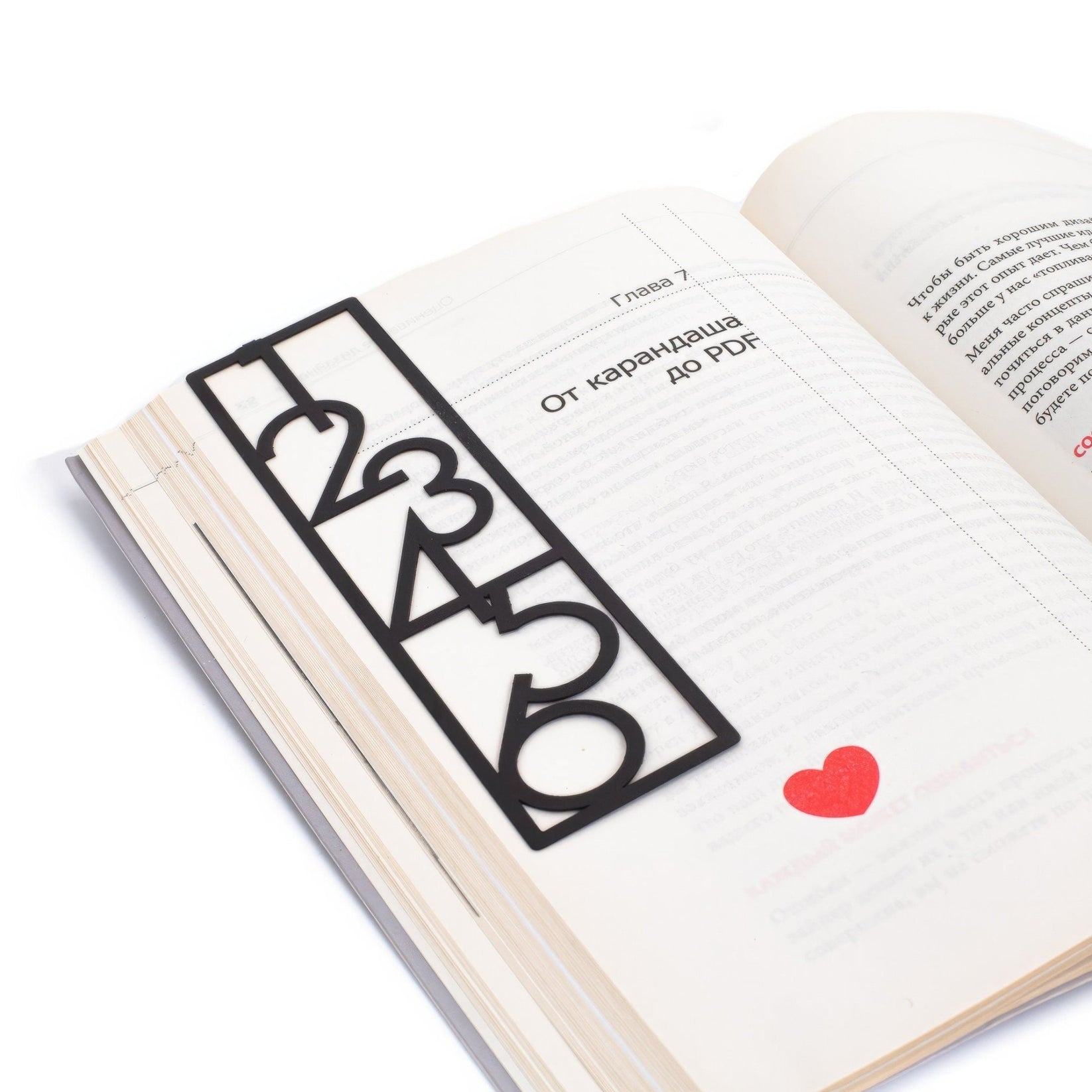 Numbers Bauhaus Style metal bookmark resting on the pages of an open book
