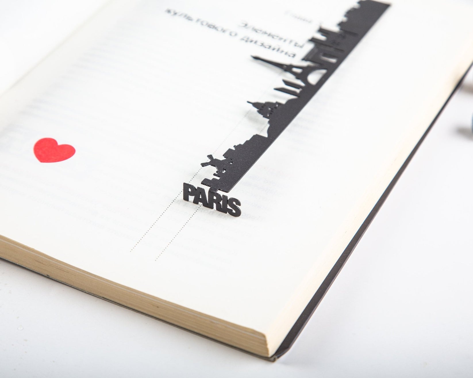 Paris metal bookmark resting on the pages of an open book