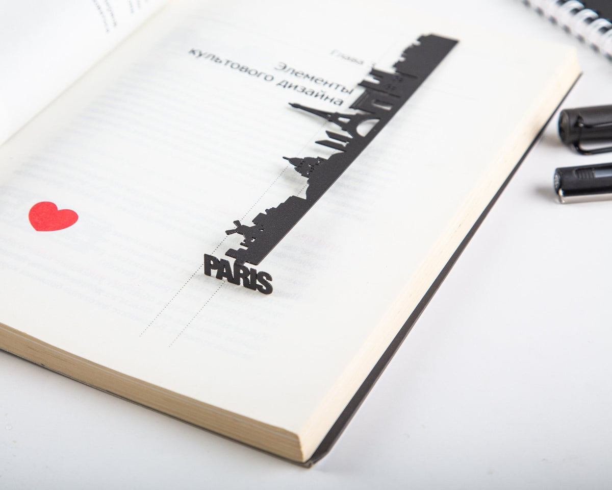 Paris metal bookmark lying across the pages of an open book