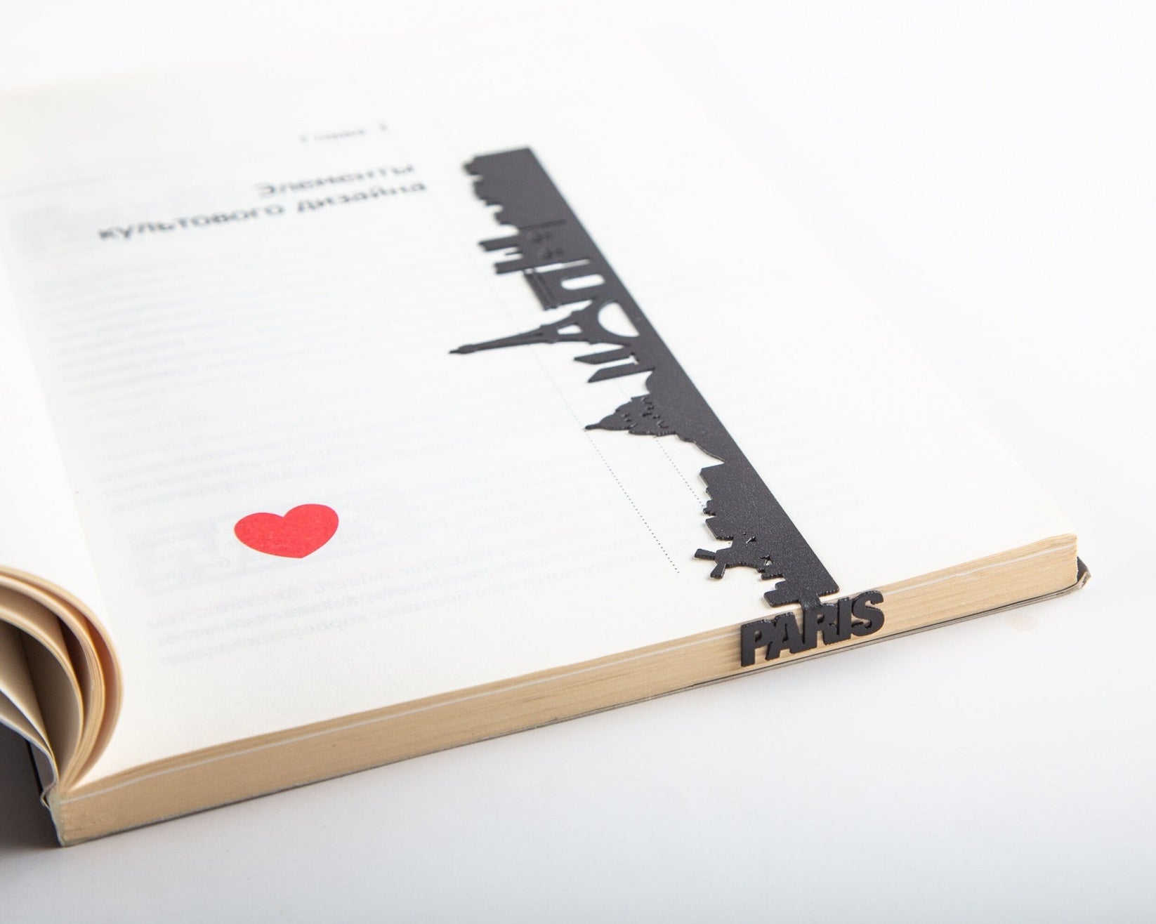 Paris metal bookmark marking a page in an open book