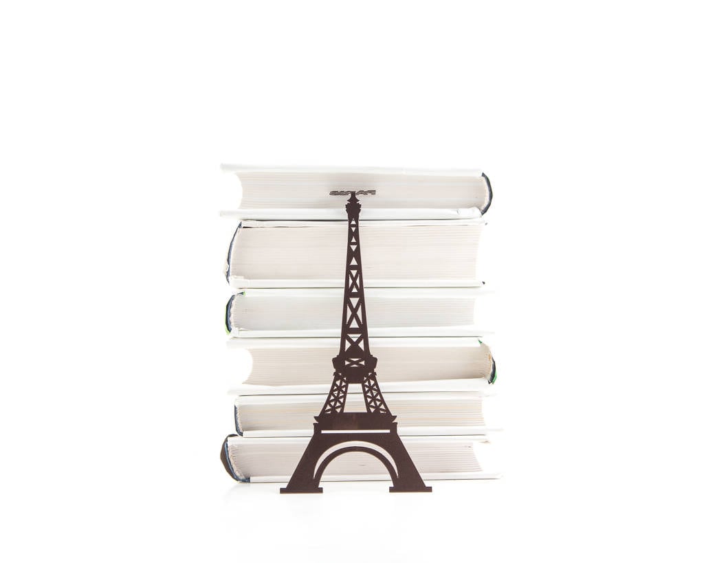 Paris Eiffel Tower metal bookmark lying on a stack of white books