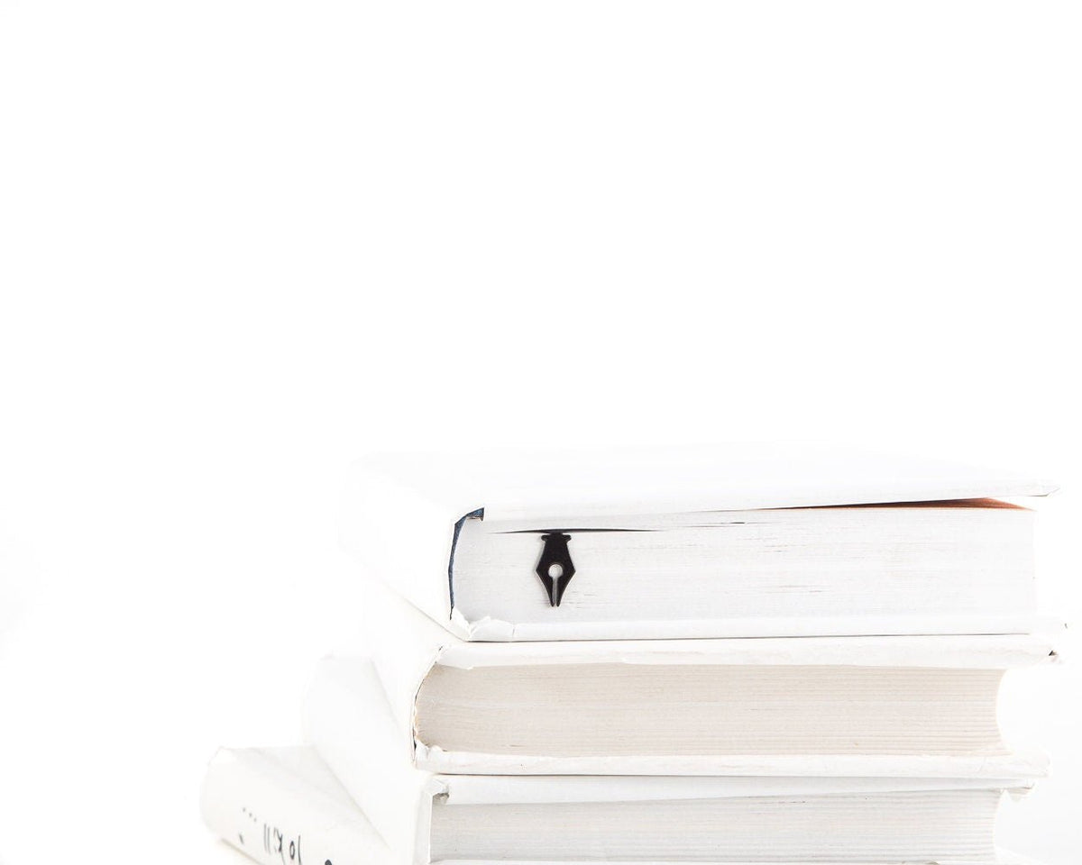 Pen Point metal bookmark shown with a stack of books