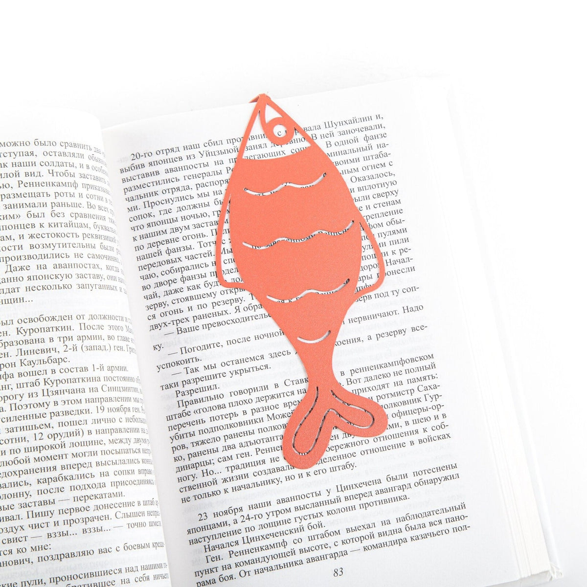 Perch metal bookmark in red resting on the pages of an open book