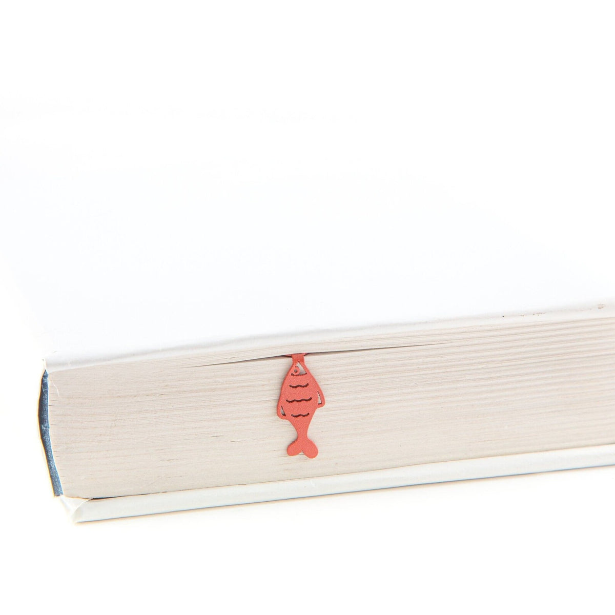 Perch metal bookmark in red in a closed book, only its top showing above the pages