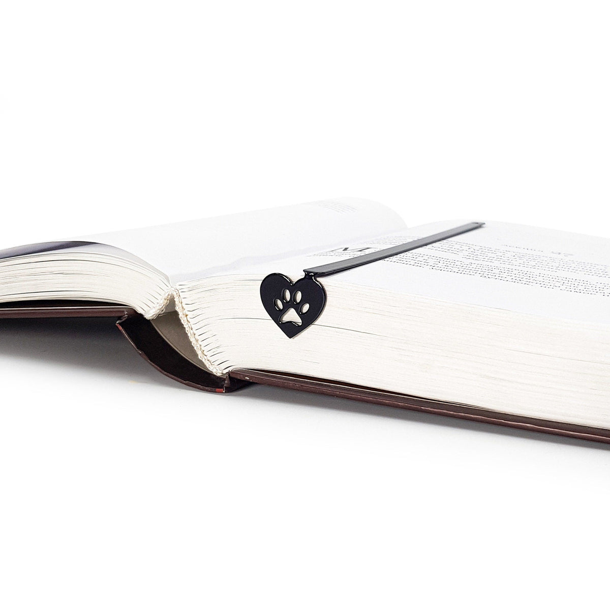 Pet Love metal bookmark resting on the pages of an open book