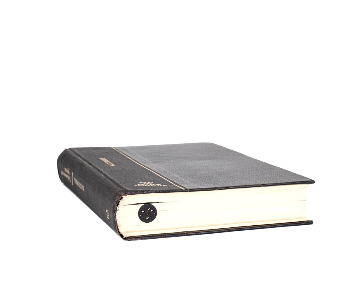 Phases of the Moon metal bookmark seen from the edge of a closed book