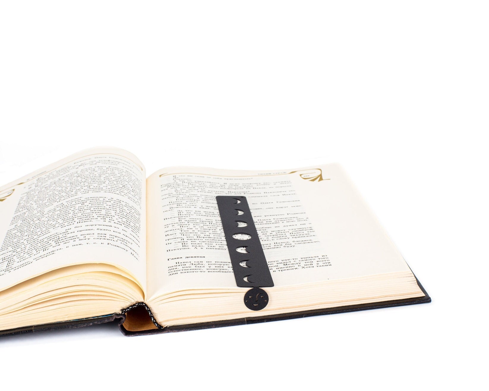 Phases of the Moon metal bookmark resting on the pages of an open book