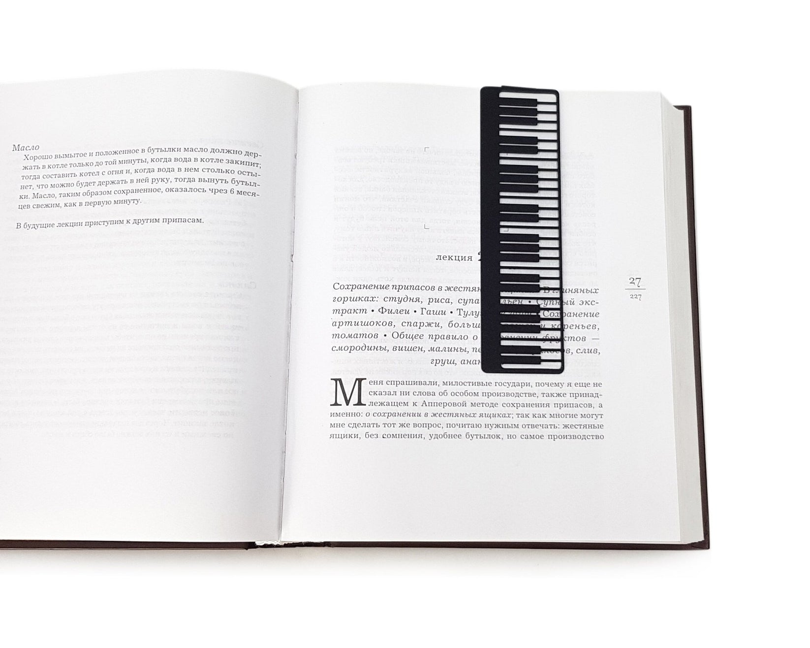 Piano Player metal bookmark resting on the pages of an open book