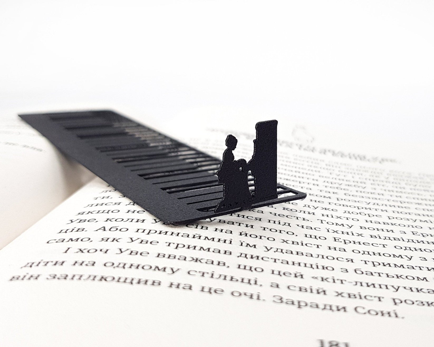 Piano Player metal bookmark set into the gutter of an open book