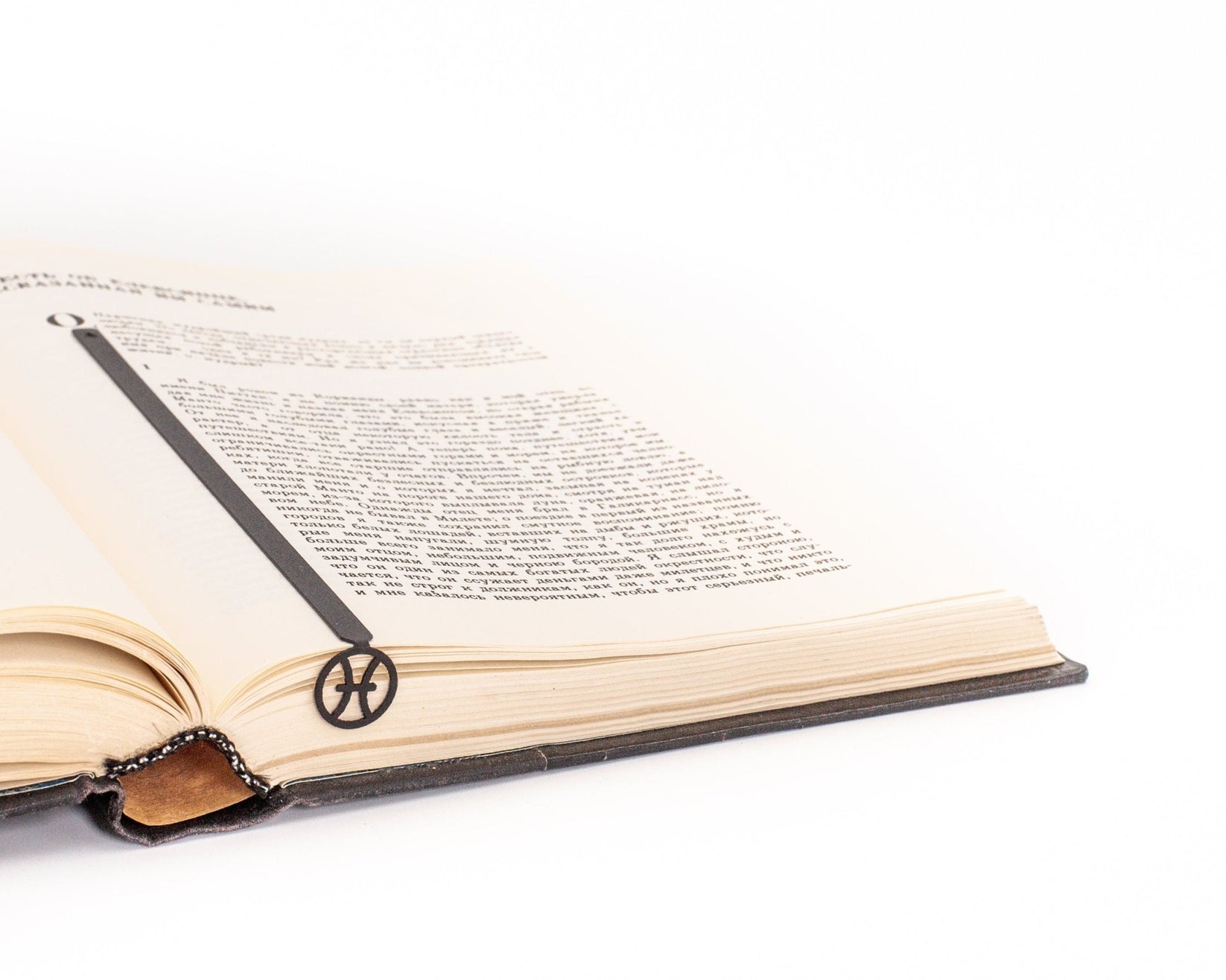 Pisces metal bookmark resting on the pages of an open book