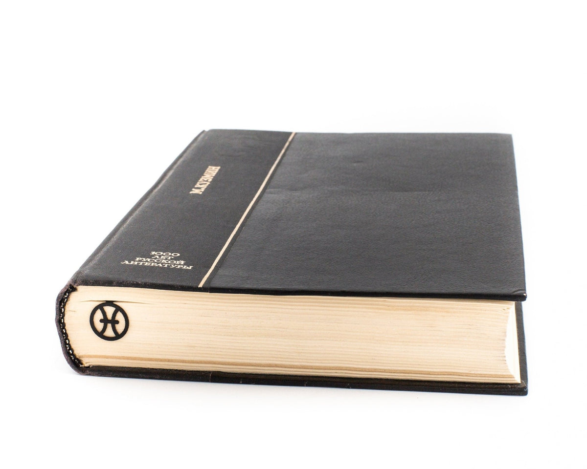 Pisces metal bookmark in a closed book, only its top showing above the pages