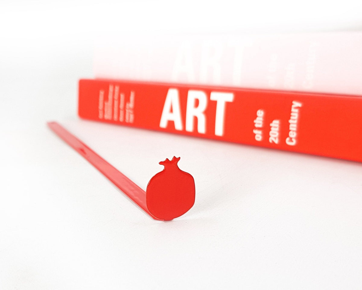Pomegranate metal bookmark in red against a coloured backdrop