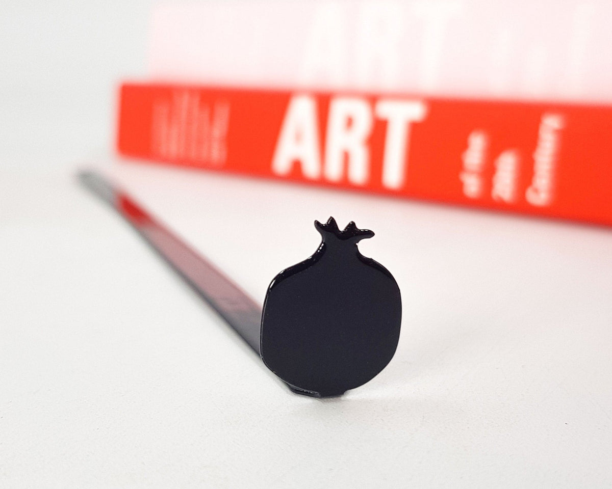 Pomegranate metal bookmark on a coloured background
