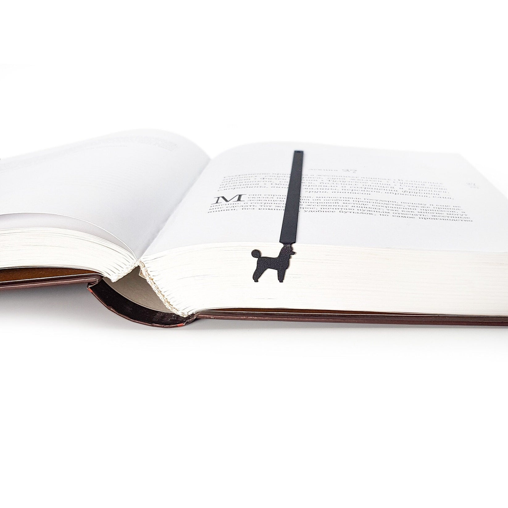 Poodle metal bookmark lying across the pages of an open book