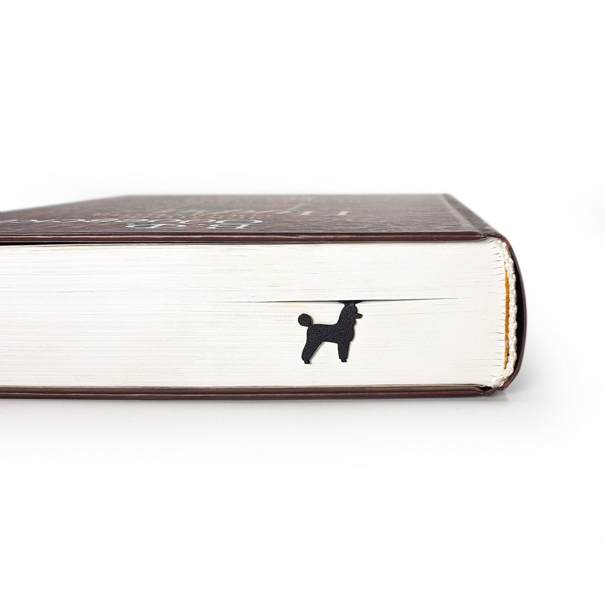 Poodle metal bookmark in a closed book, only its top showing above the pages