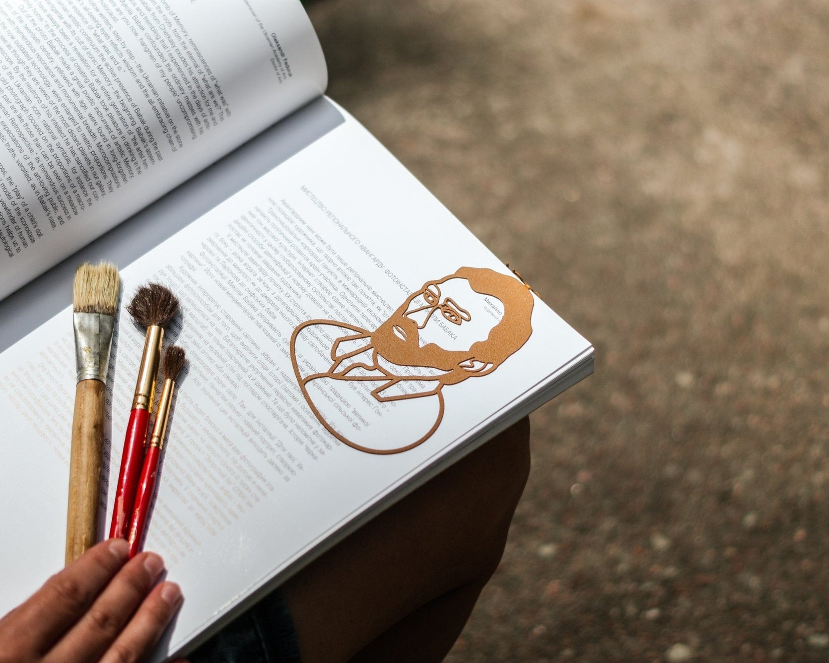 Van Gogh Portrait metal bookmark in gold marking a page in an open book