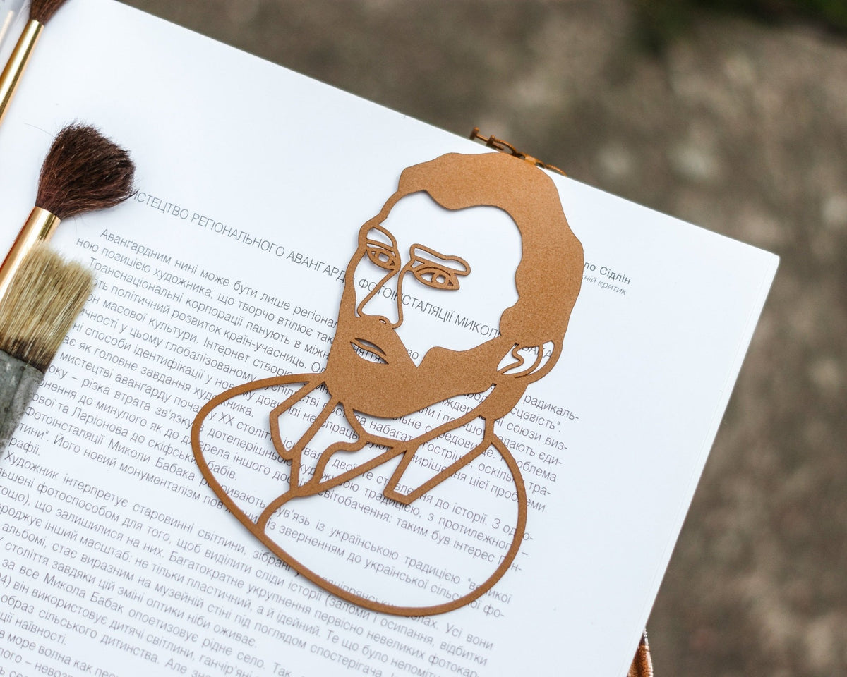 Van Gogh Portrait metal bookmark in gold resting on the pages of an open book