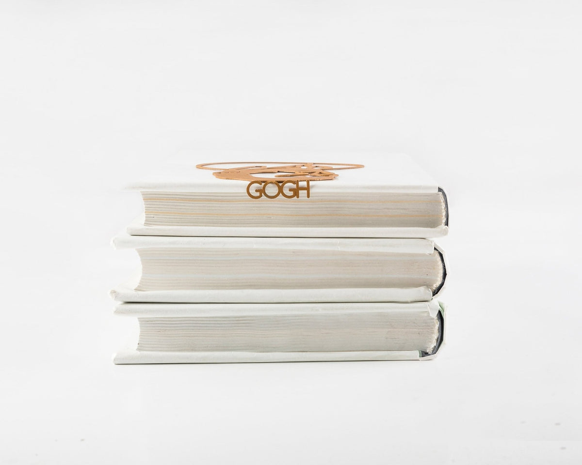 Van Gogh Portrait metal bookmark in gold shown with a stack of books