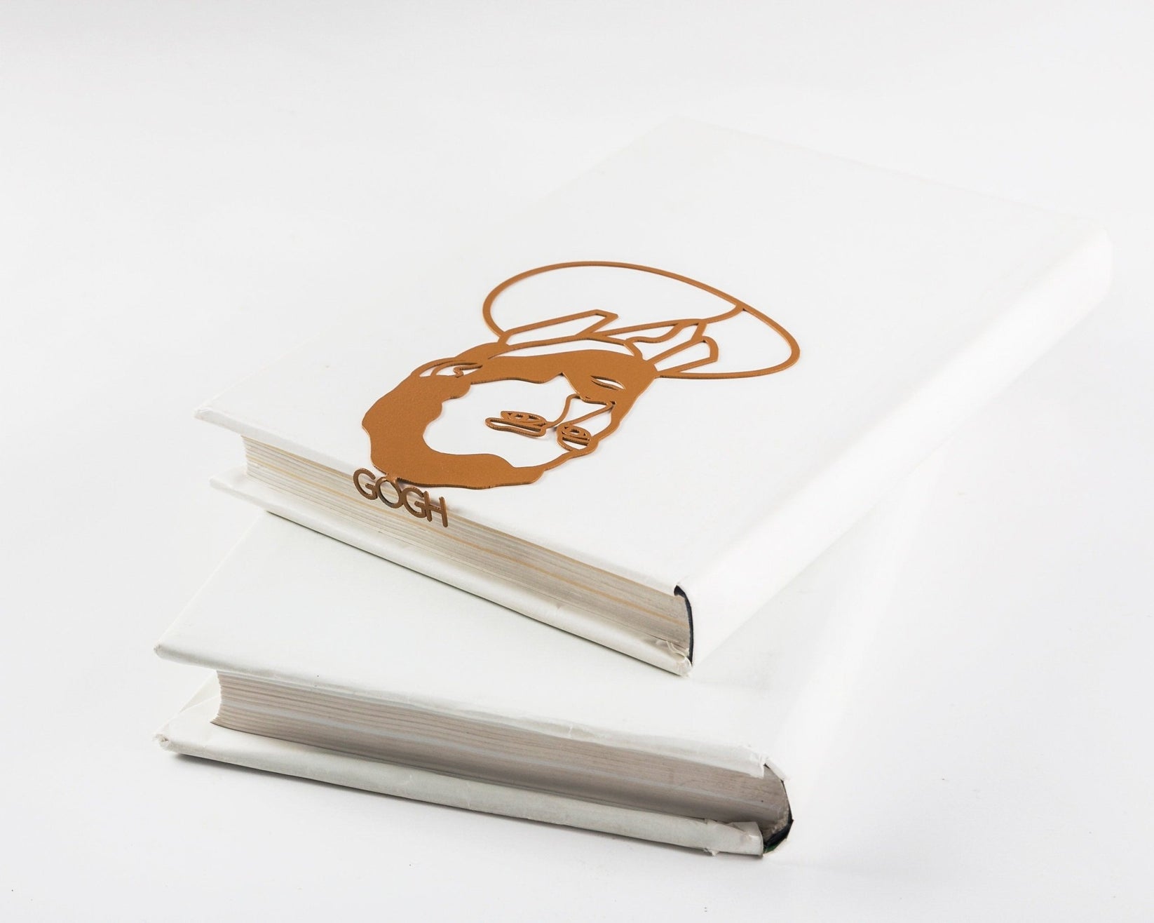 Van Gogh Portrait metal bookmark in gold in a closed book, only its top showing above the pages